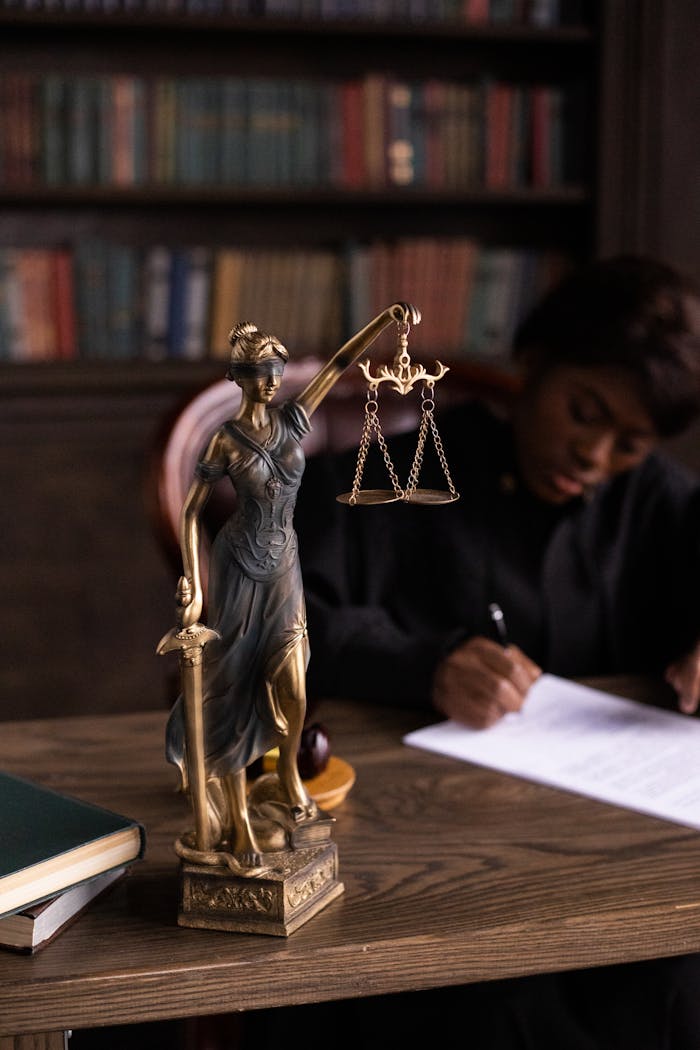 Mastering the First Impression: Your intriguing post title goes here Close-up of Lady Justice figurine on a lawyer's desk with books and documents.
